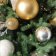 Christmas tree decorated with gold, silver, and white ornaments and ribbons, creating a festive holiday mood.