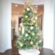 Elegant Christmas tree with gold and silver ornaments in a modern holiday living room.
